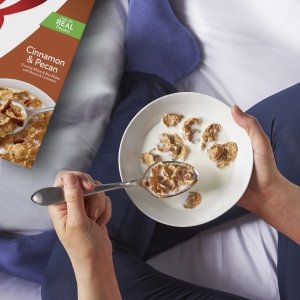 Enjoy cereal with milk at night as a treat like this young woman in leggings relaxing on her bed